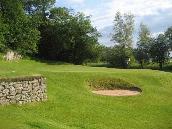 A view of green #8 guarded by bunkers at Grange-over-Sands Golf Club