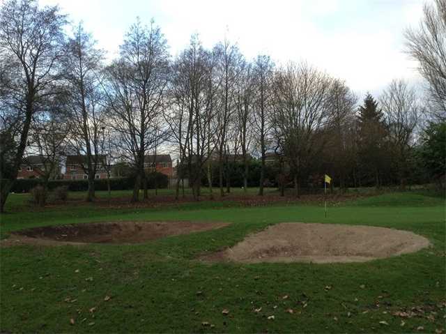 A view of green guarded by sand traps at Pastures Golf Club