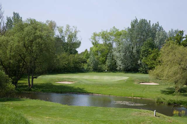 A view over the pond of green flanked by sand traps at Mill Hill Golf Club