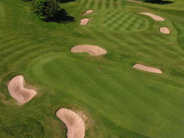 Aerial view of green protected by bunkers at Saddleworth Golf Club