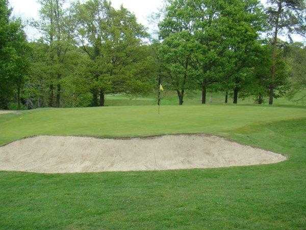 A view of the 15th green guarded by bunker at Romsey Golf Club