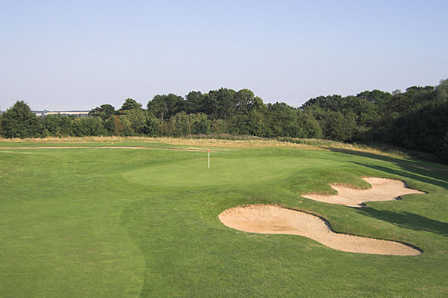 A view of a green protected by sand traps at Hertfordshire Golf Club