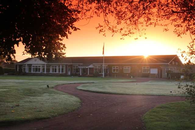 Holme Hall clubhouse set against a sunset backdrop