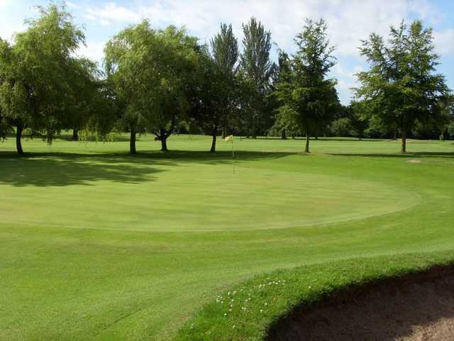 A view of a green guarded by bunker at Woolton Golf Club