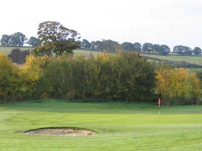 A view of the 1st green guarded by bunker at Rothbury Golf Club