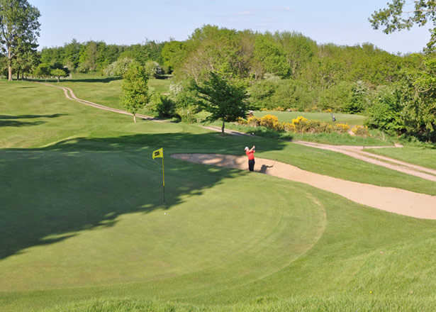 A view of a green with narrow path on the right side at Taunton & Pickeridge Golf Club