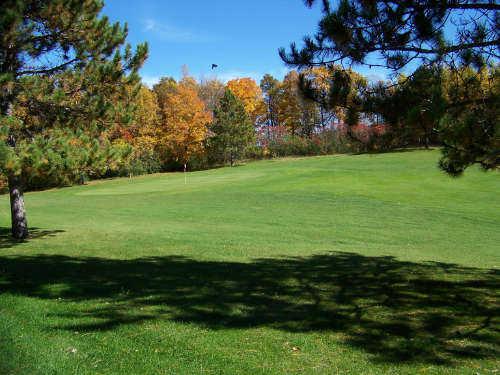 A view from a fairway of a green guarded by colorfull fall trees at Tianna Country Club