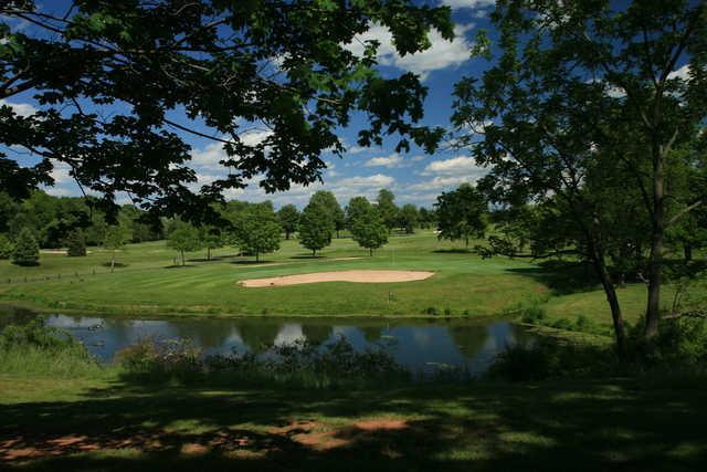 A view over the water of a hole guarded by tricky bunkers at Spooky Brook Golf Course