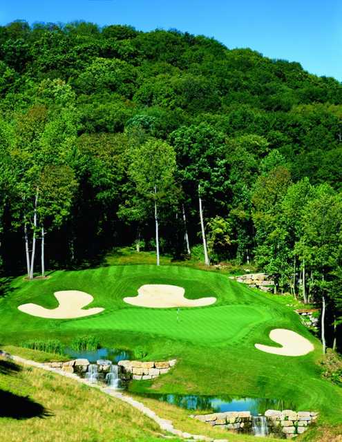 A view of the 14th green protected by bunkers at Olde Stonewall Golf Club