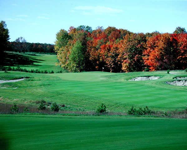 A fall view of a hole guarded by sand traps at Red from Mistwood Golf Course