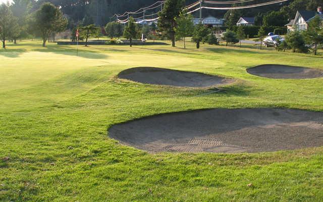 A view of a green protected by bunkers at Metchosin Golf and Country Club
