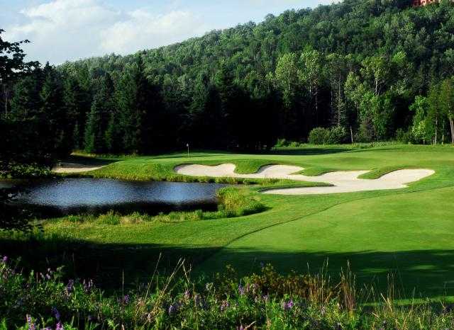 A view of a green with water on the left side at Le Maitre de Mont-Tremblant