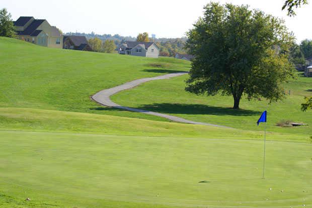 A view of a green with a cart path in background at River Oaks Golf Club