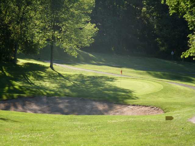 A view of a green protected by a sand trap at Oak Lake Golf Course