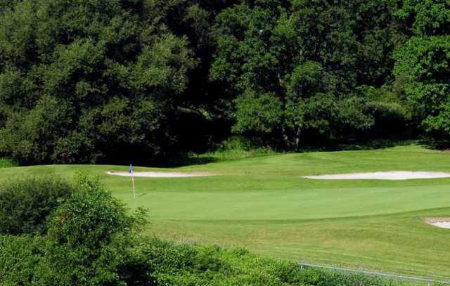 A view of a green protected by tricky bunkers at Cedar Creek Golf Club