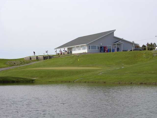 A view over the water of green #9 and clubhouse at Oshawa Airport Golf Club