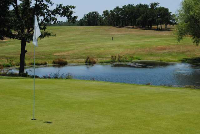 A view of a green with water coming into play at Twisted Oaks Golf Club