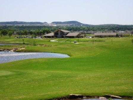 A view from a fairway with the clubhouse in the distance at Harbor Lakes Golf Club