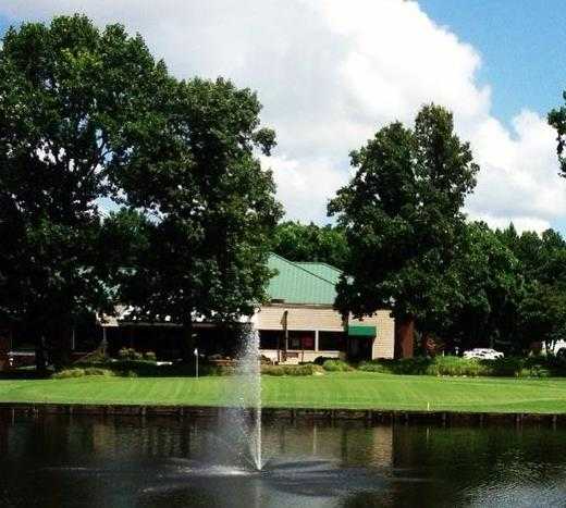 A view over the water of the 18th green and the clubhouse at Birchwood Country Club