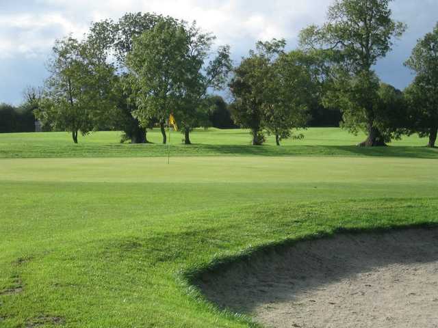 A view of green #18 guarded by bunker at Castle Barna Golf Club