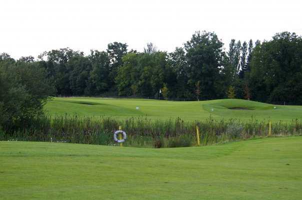 A view over a pond of the 4th green at Grange Castle Golf Club