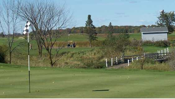 A view of a hole with a bridge in background at Bulrush Golf Club