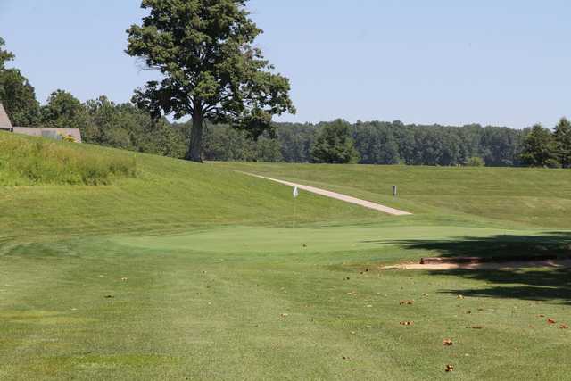 A view of a green with a narrow path in background at Hidden Hills Golf Course
