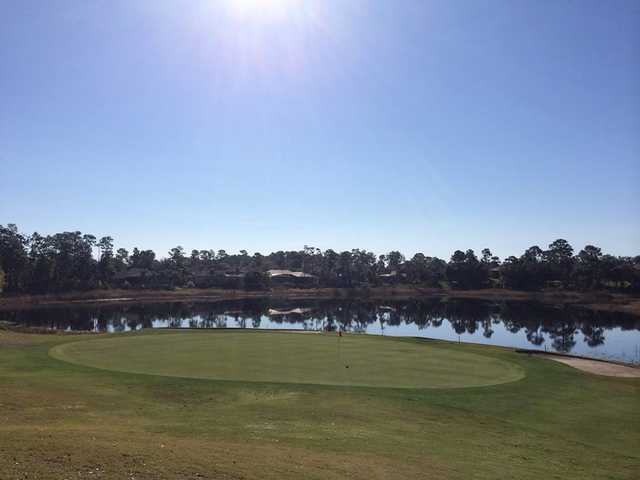 A sunny day view of a green with water in background at DeBary Golf and Country Club