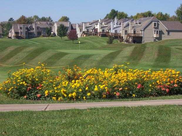 A view of a green surrounded by flowers at Teetering Rocks Links