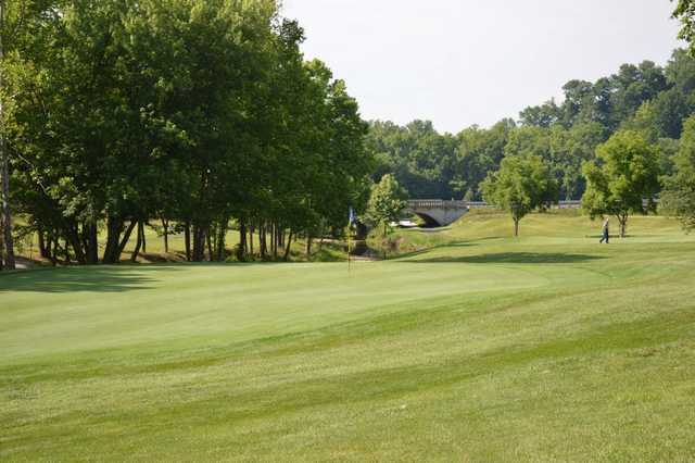 A view of a green with a bridge in background at Lucas Oil Golf Course