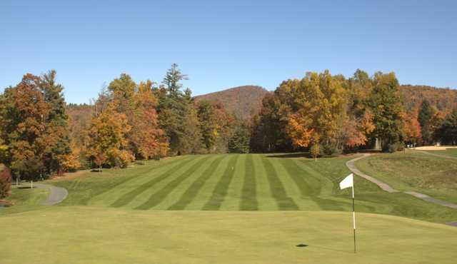 A view of a green with a narrow path on the left side at Boone Golf Club