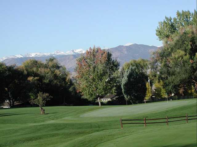 A view of a green with mountains in background at Sunset Golf Course