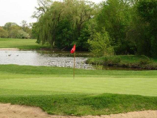 A view of a green with water in background at Briarwood Country Club