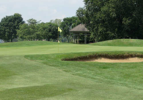 A view of a green protected by a bunker at Streamwood Oaks Golf Club