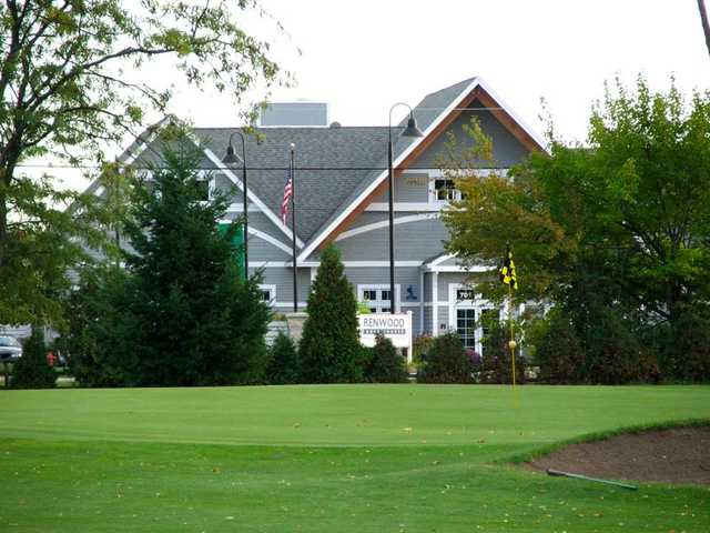 A view of a green guarded by a bunker and the clubhouse in background at Renwood Golf Course
