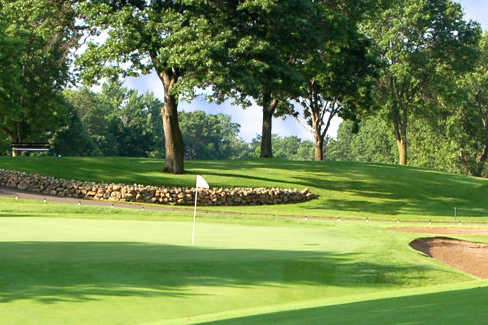 A view of a green protected by bunkers at Hillcrest Country Club