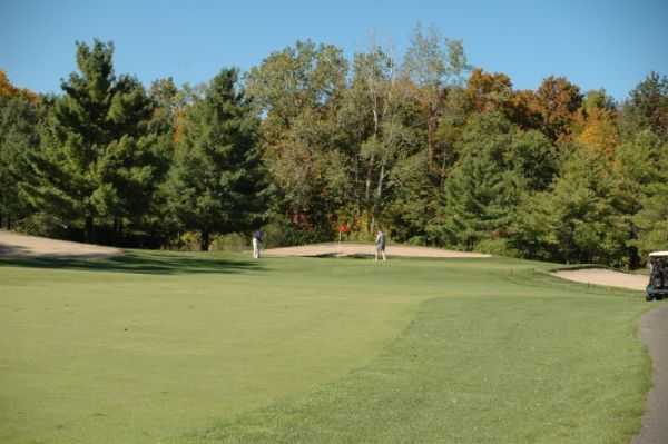 A view of a green protected by tricky bunkers at Fox Creek Golf Course