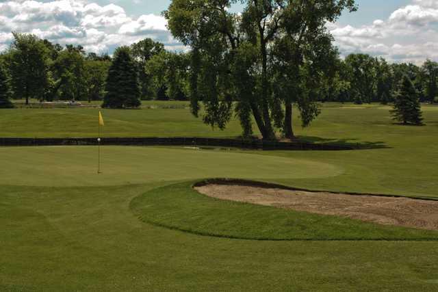 A view of a green protected by a pond and a bunker at Gold from Winding Creek Golf Course