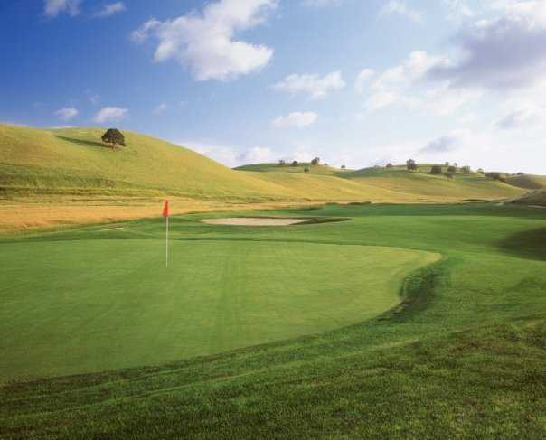 A view of a green protected by sand traps at Deer Ridge Golf Club