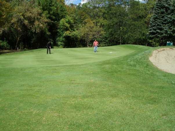 A view of a green protected by a large bunker at Harbour Club Golf Course