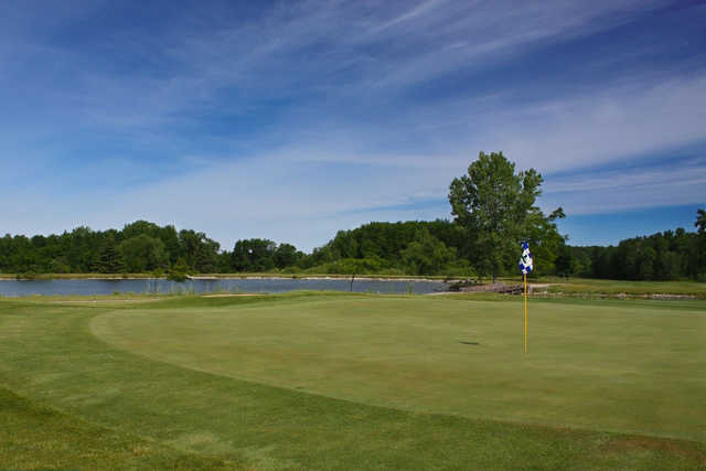 A view of a green with water in background at Idlewild Golf Course