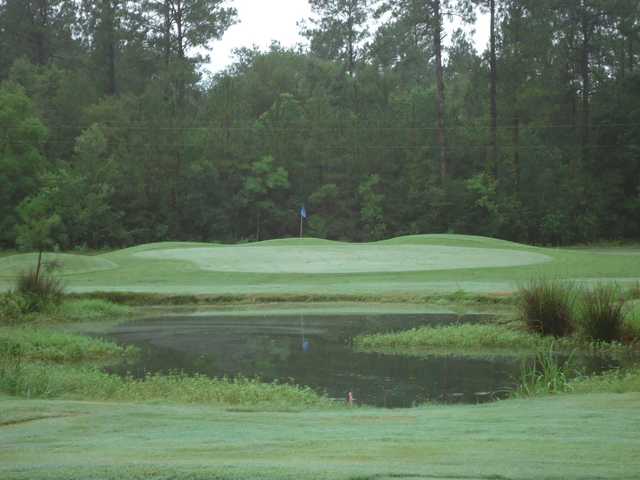 A view of a green protected by a pond at Abita Springs Golf & Country Club