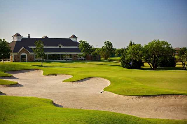 A view of a green protected by a large bunker at Tangle Ridge Golf Club