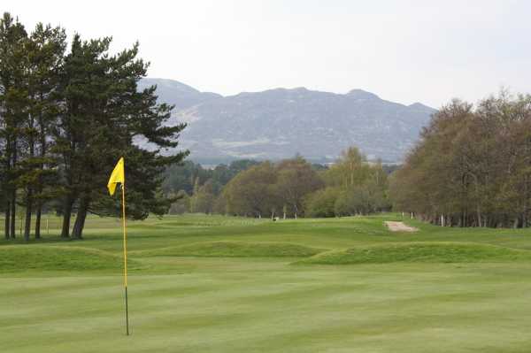 A view of a hole with mountains in background at Newtonmore Golf Club