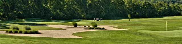 A view of a green protected by a bunker at Robin's Nest Golf Course