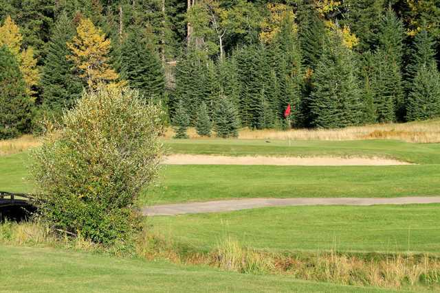 A view of a green protected by a bunker at Tomahawk Lake Country Club