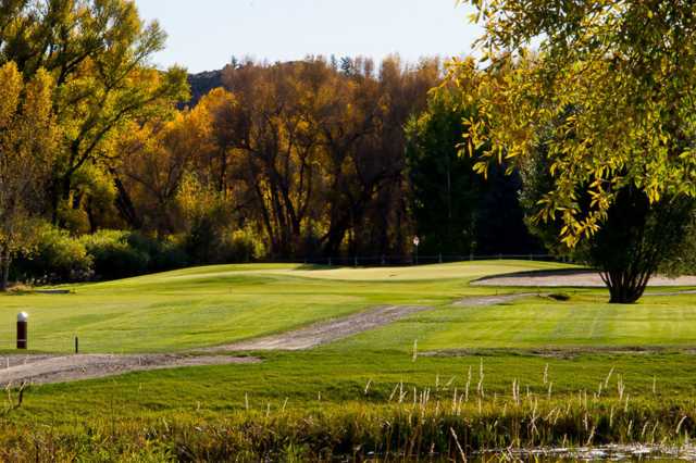 A view of a green protected by a bunker at Dos Rios Country Club