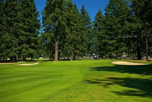 A view of the 16th green flanked by bunkers at Lake Spanaway Golf Course