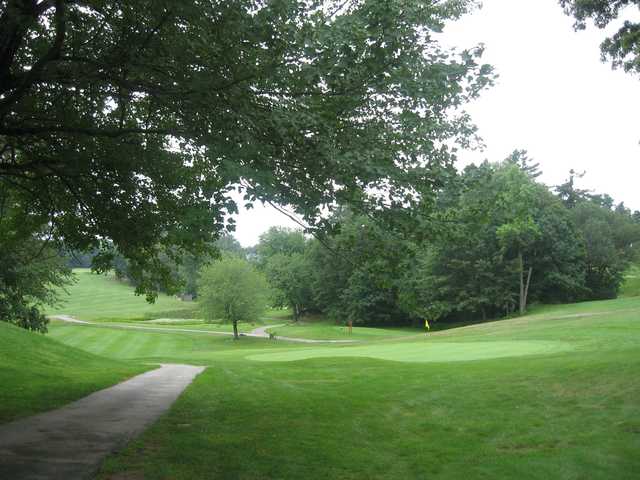 A view of a green with a narrow path on the left side at Berlin Country Club