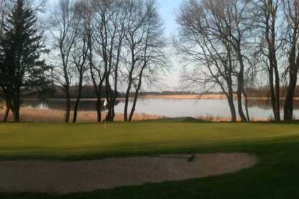 A view of a green with water in background at Waseca Lakeside Golf Club